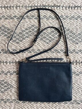 Coccinelle navy leather crossbody purse clutch bag with removable strap.